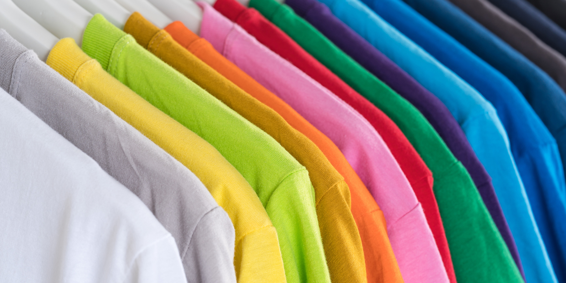 Stack of multicolored t shirts on hangers